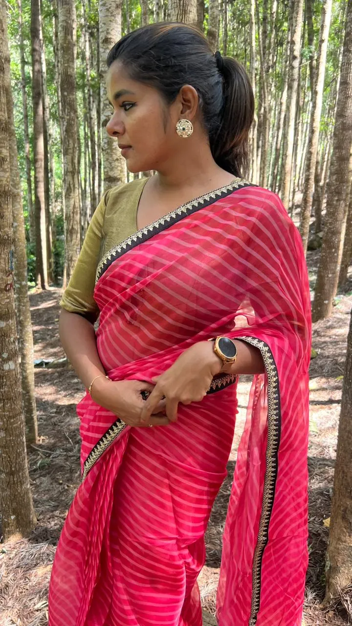 Pink stripped organza saree with black & gold blouse