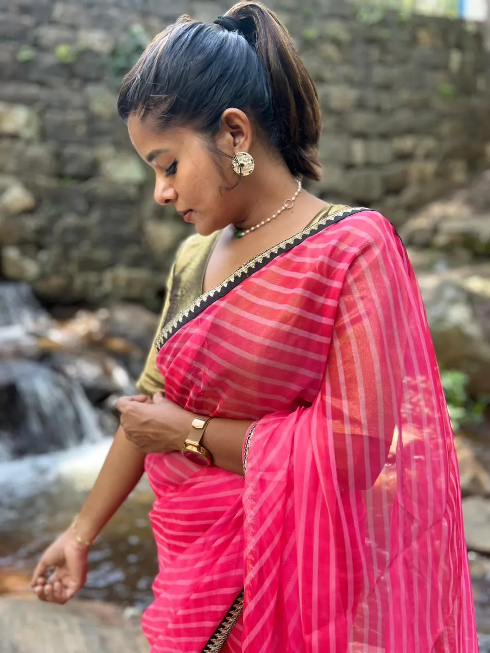 Pink stripped organza saree with black & gold blouse