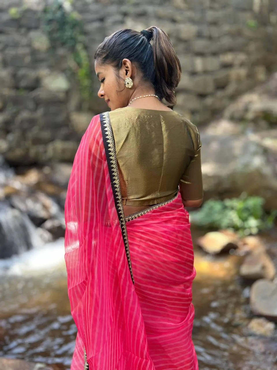 Pink stripped organza saree with black & gold blouse