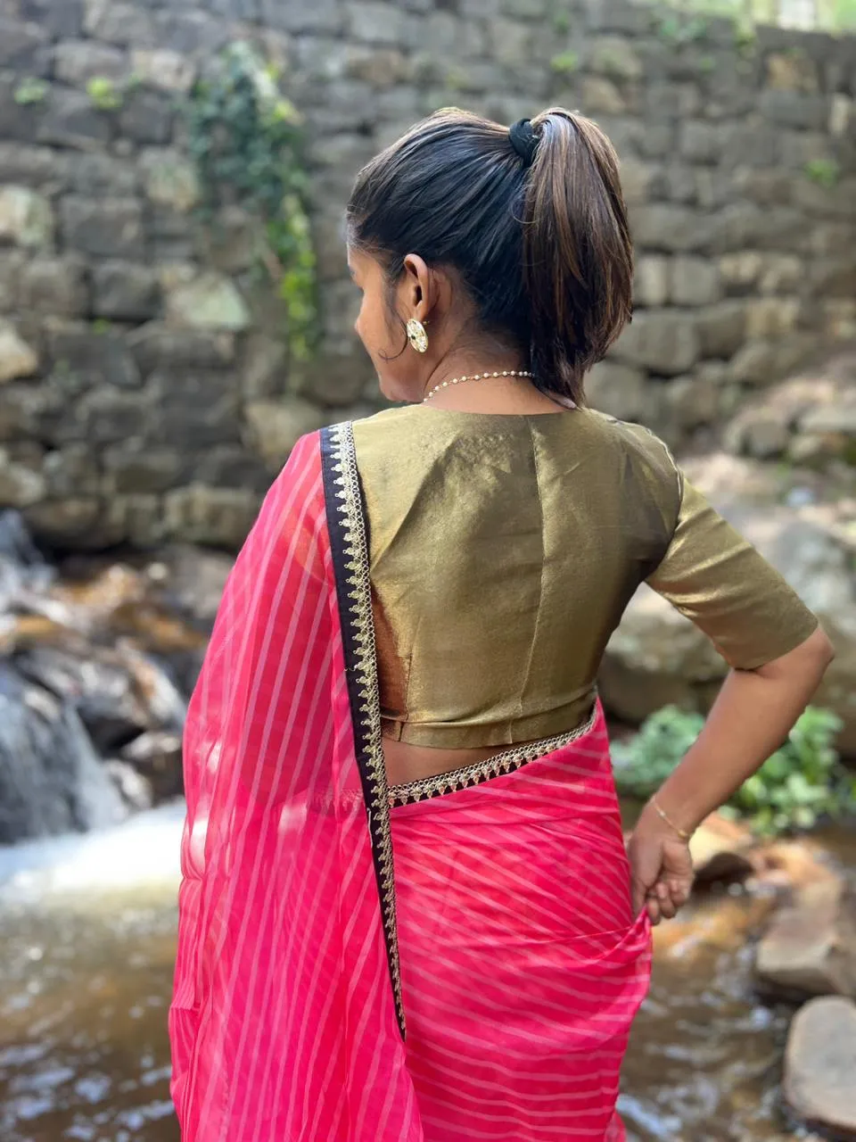 Pink stripped organza saree with black & gold blouse